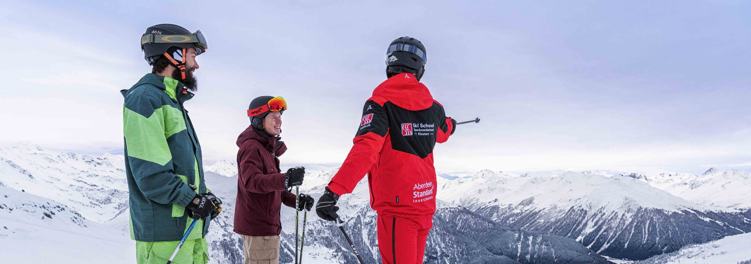 Ski course for adults with two participants and a ski instructor from the Klosters Ski School